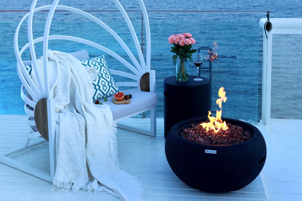 YORK fire bowl with a lit fire on a seaside terrace