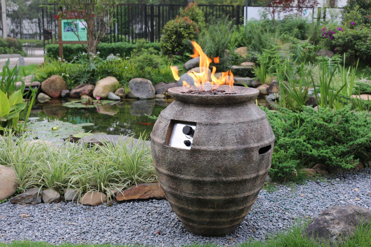 POMPEI POT fire pit with a lit fire in a garden