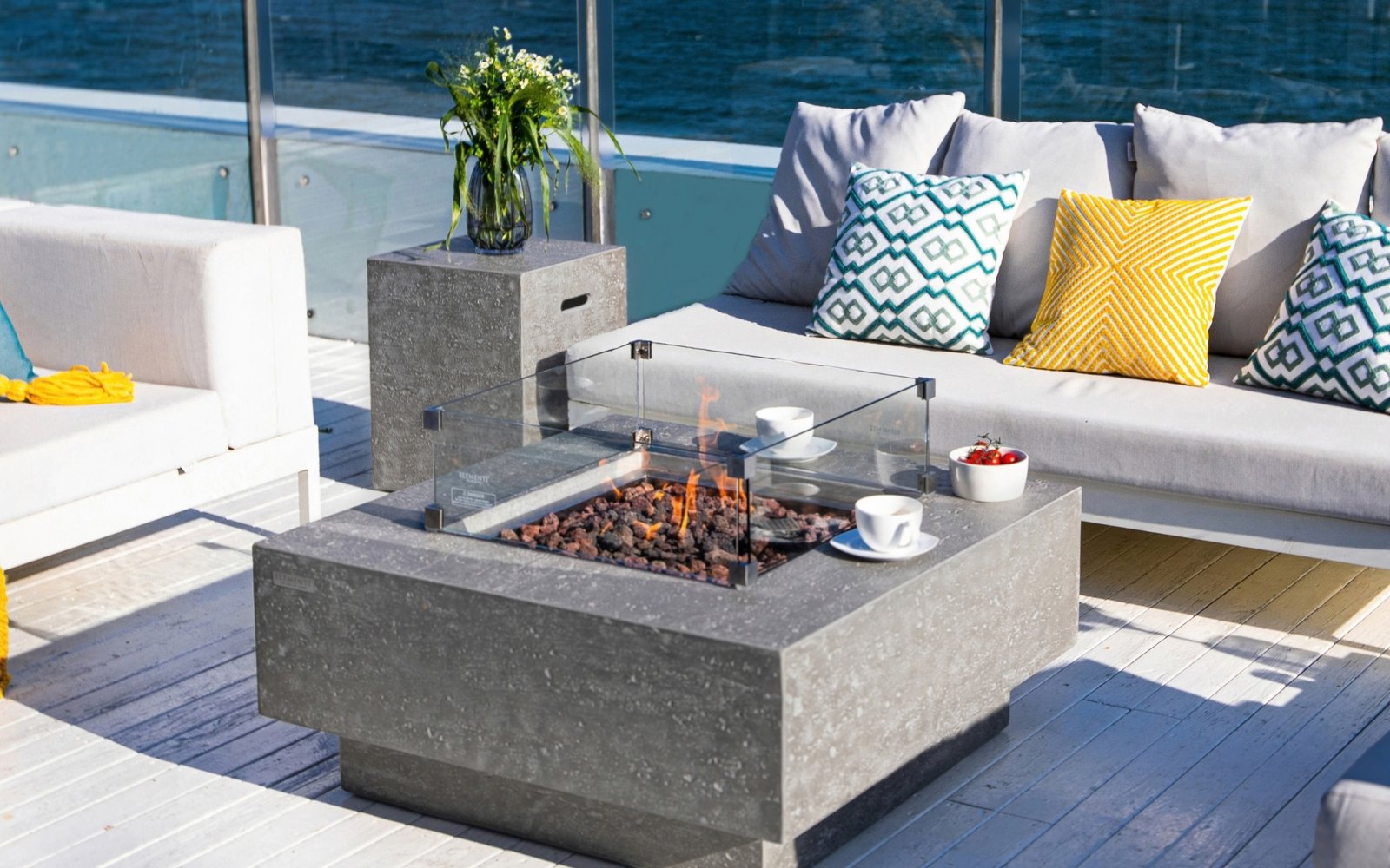 LG bottle cover with a travertine finish next to the MANHATTAN fire pit on a terrace