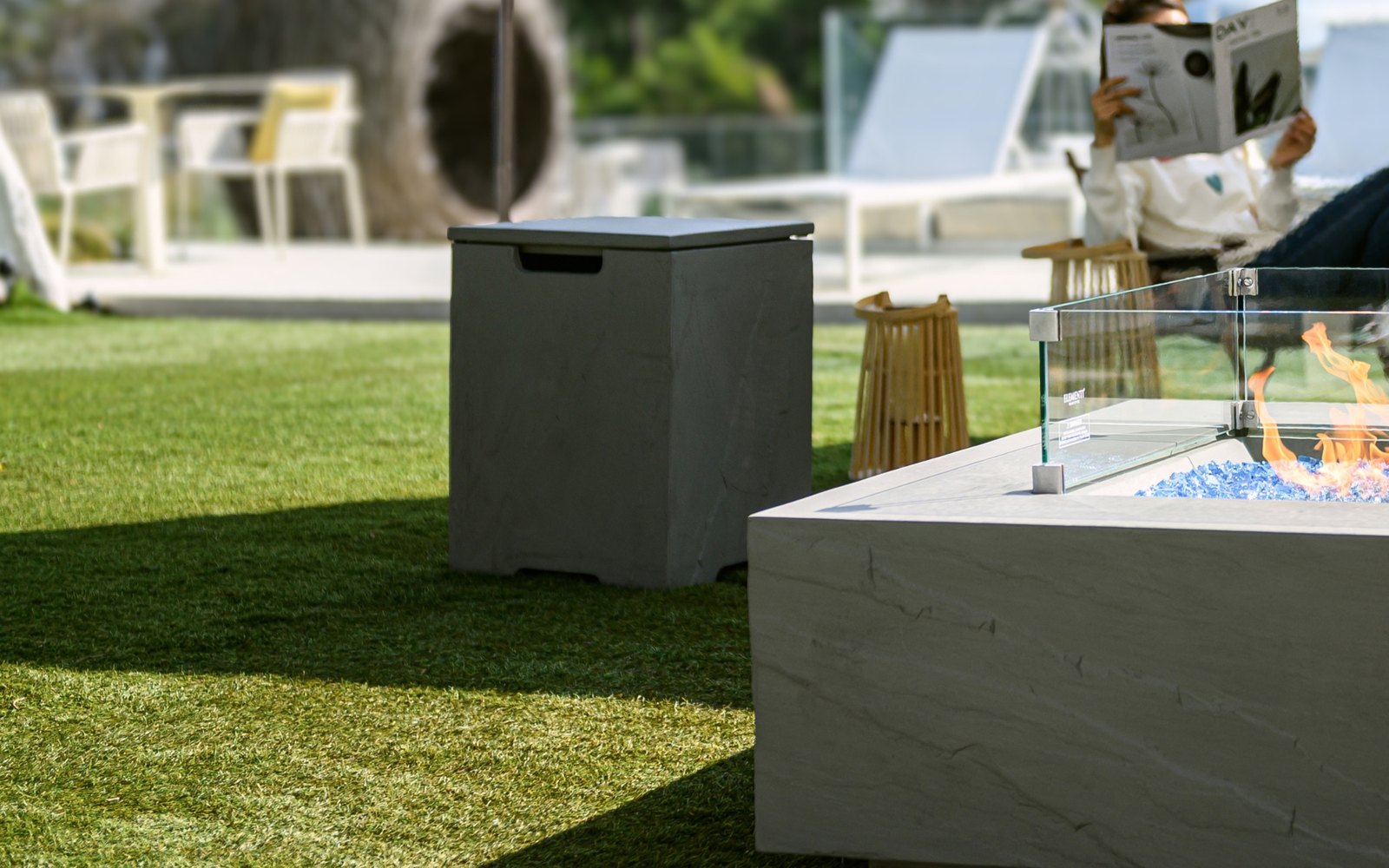 Light grey bottle cover with a lid next to a fire pit on the lawn