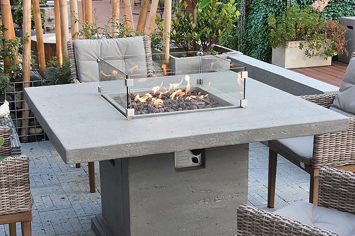 Glass wind guard on a fire pit dining table