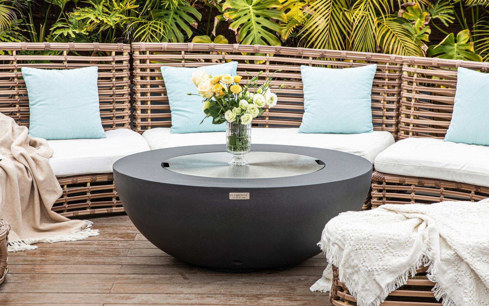 LUNAR BOWL fire pit with the stainless steel lid and a bouquet on a terrace