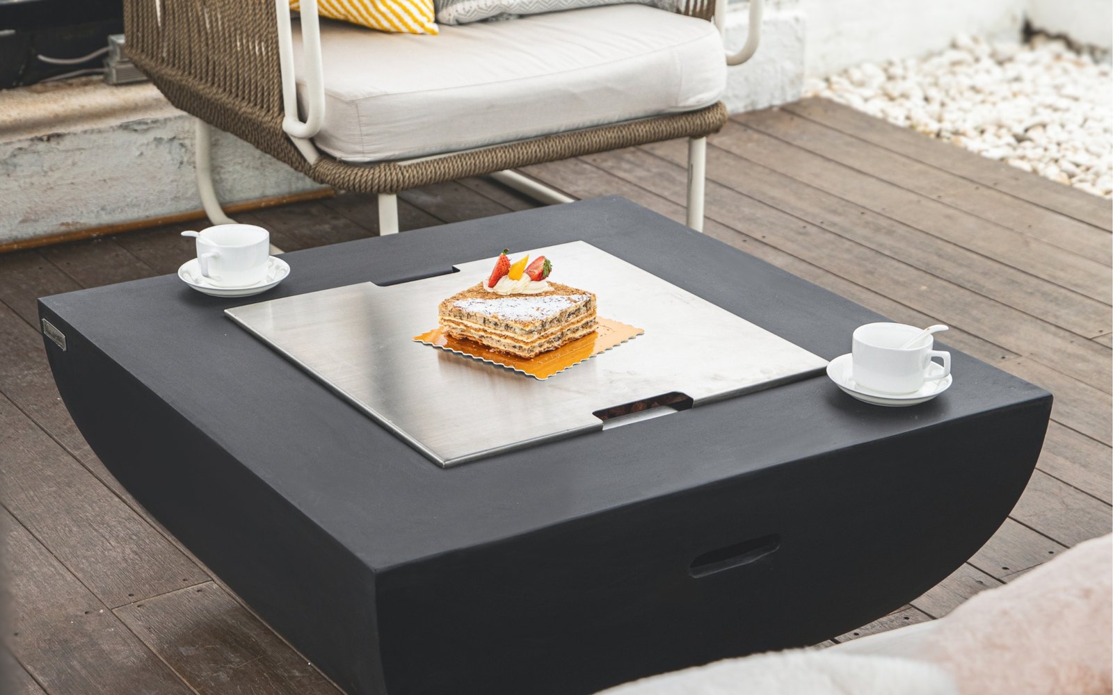 AURORA fire pit with the stainless steel lid used as a table for coffee and dessert