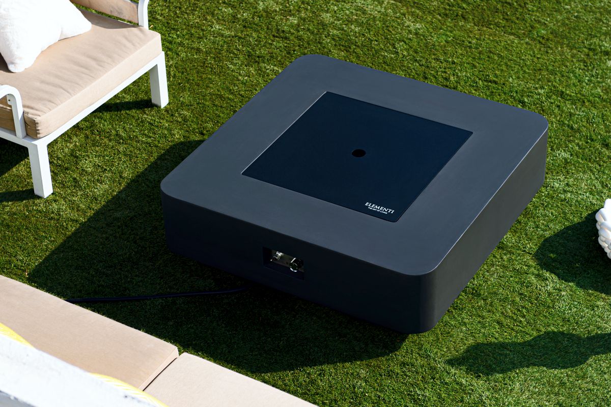 BERGAMO table with the fire pit lid on, on a lawn