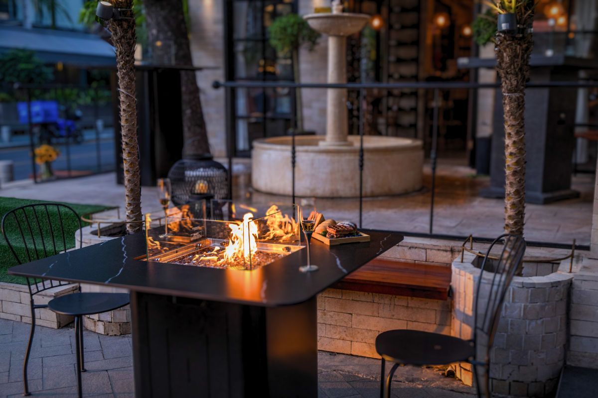 BRUGGE table with a lit fire on a restaurant terrace