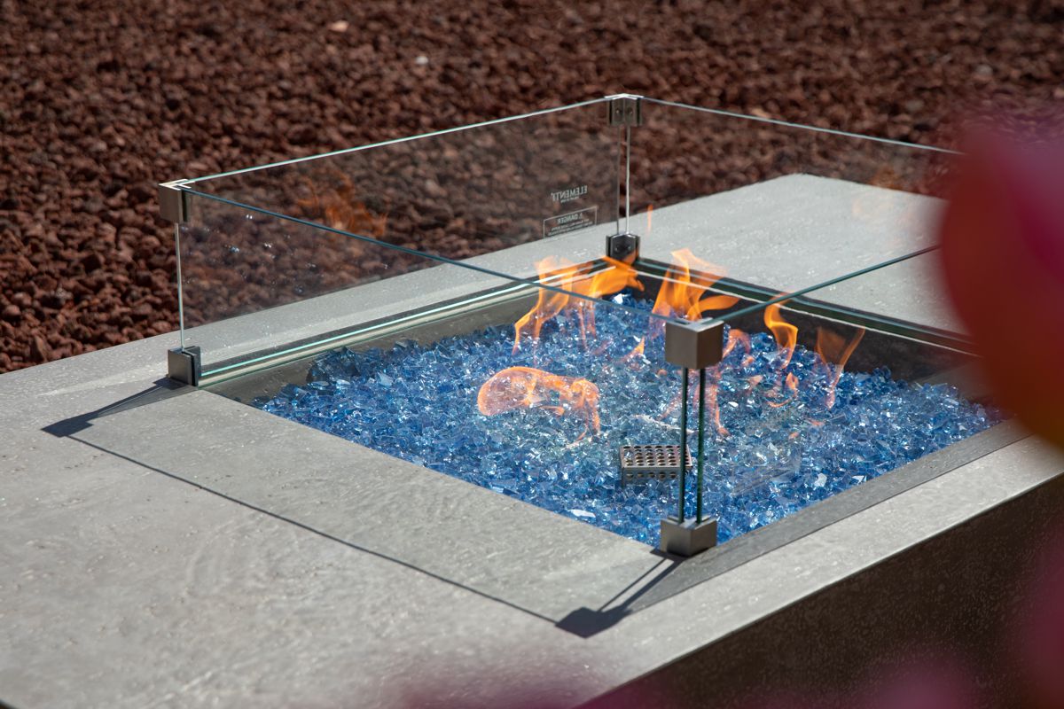 The lit fire of the MONTE CARLO table with the glass wind guard