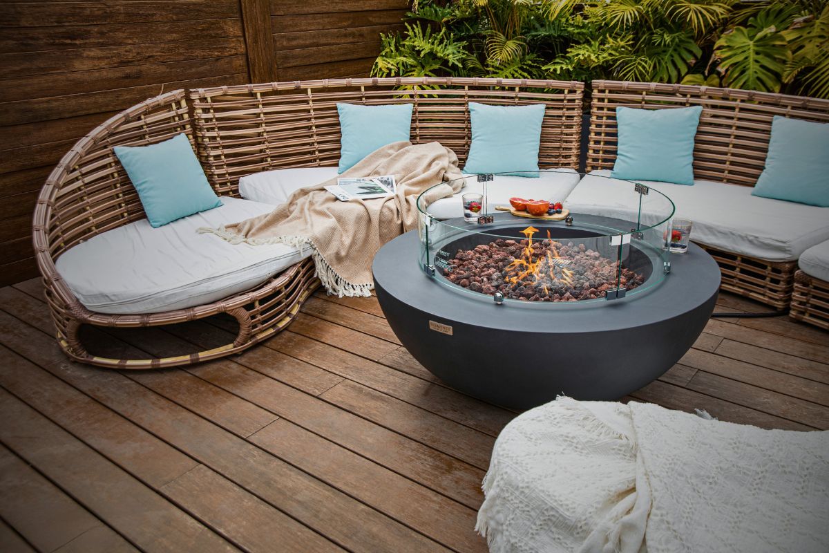 LUNAR BOWL Dark Grey fire pit on a terrace by a curved sofa
