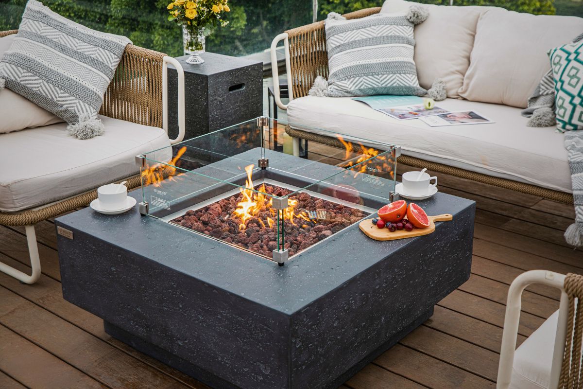 MANHATTAN Dark Grey table with the glass wind guard and bottle cover on a terrace