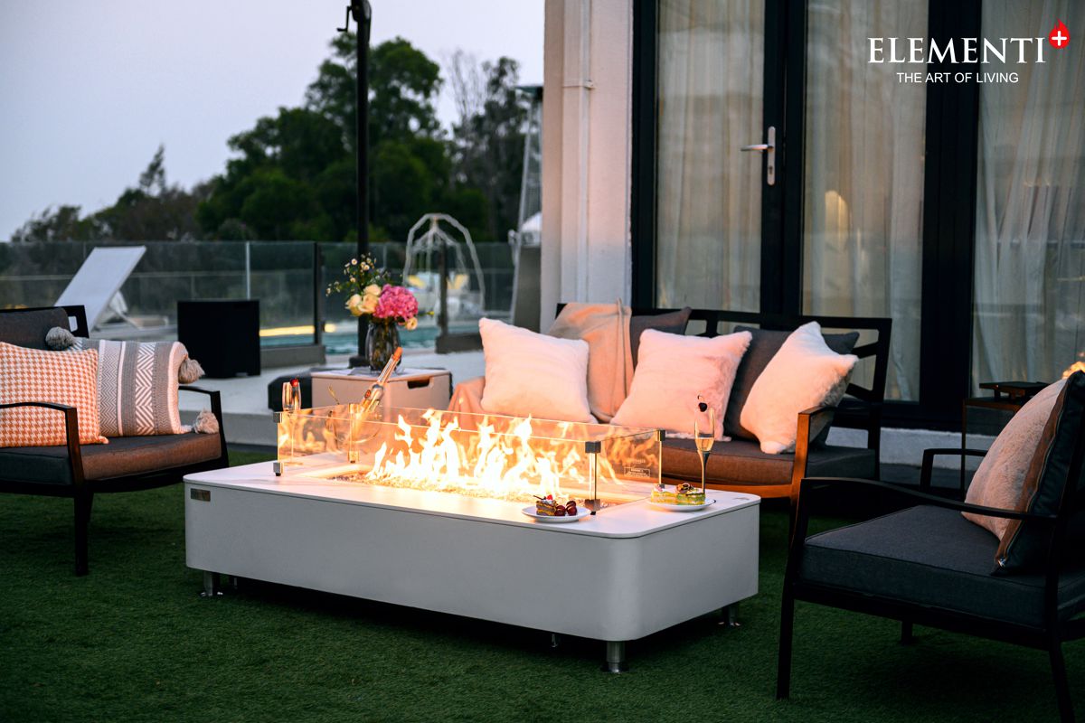 ATHENS table with a lit fire on a terrace in front of a sofa