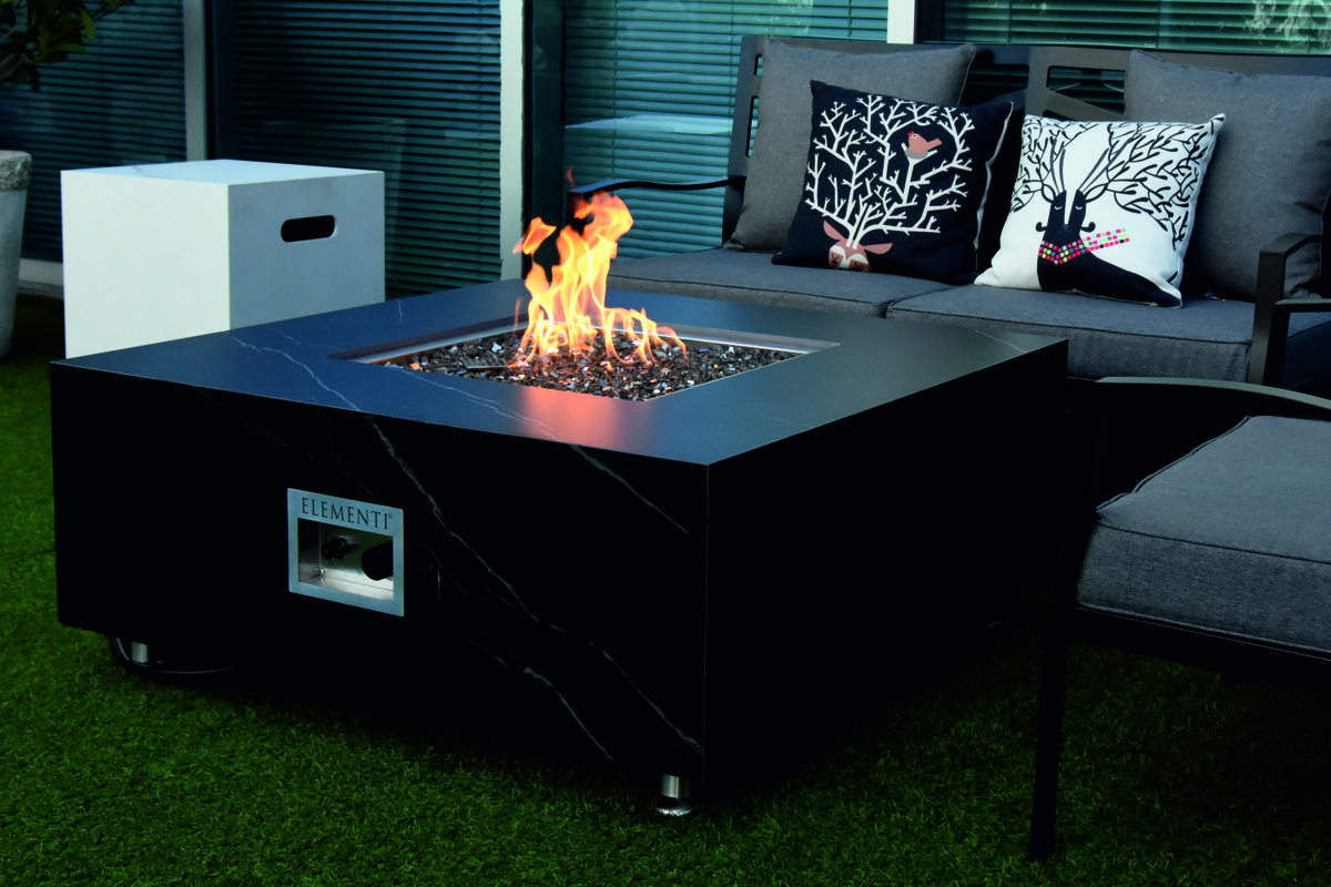 SOFIA table with a lit fire on a terrace in front of a sofa