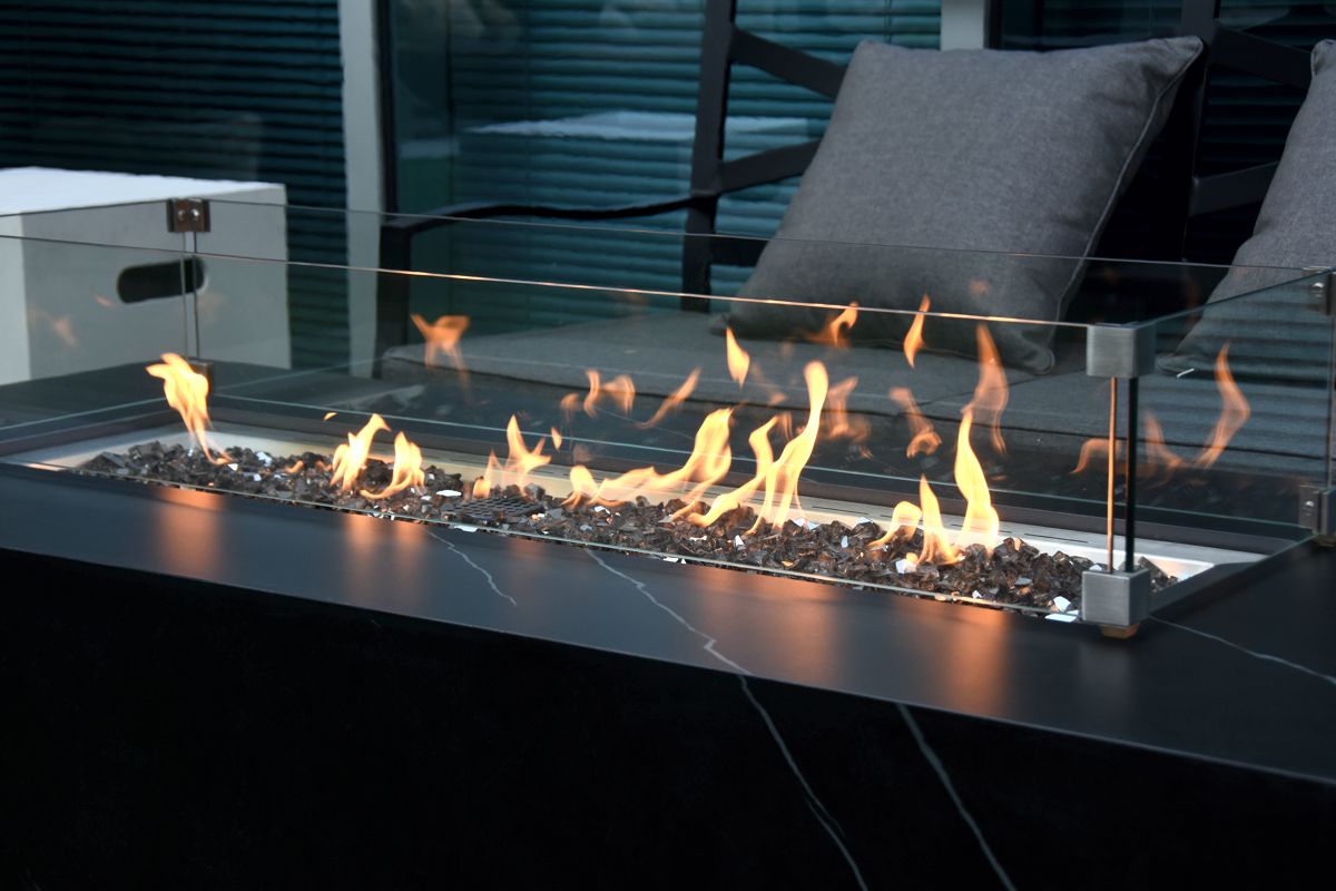 The lit fire of the VARNA table with the glass wind guard