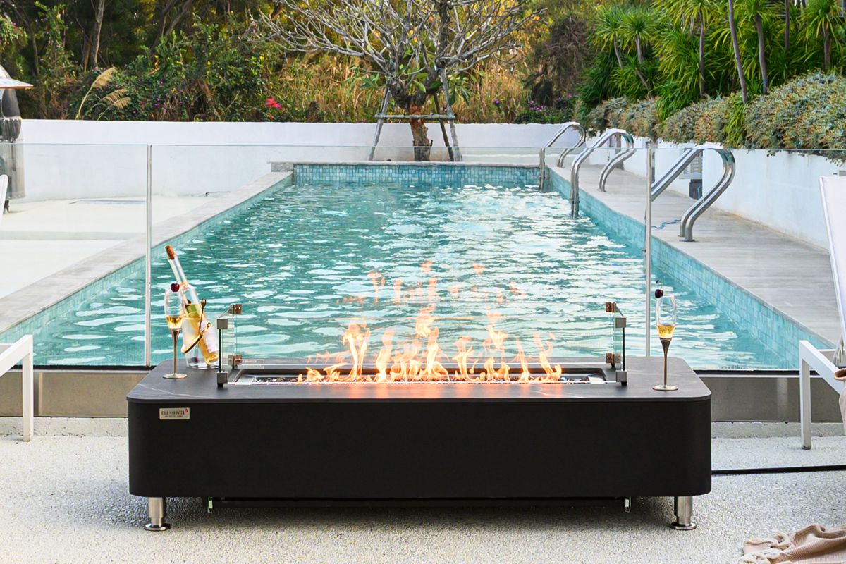 VALENCIA table with a lit fire by the pool